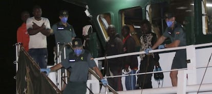 Diversos immigrants rescatats dimarts quan navegaven en una pastera esperen per desembarcar en arribar al port d'Almeria.