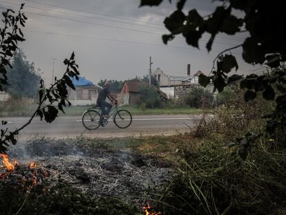 Un hombre circulaba ayer viernes en bicicleta en la localidad ucrania de Ruski Tishki, a 17 kilómetros de la frontera rusa.