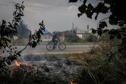 Un hombre circulaba ayer viernes en bicicleta en la localidad ucrania de Ruski Tishki, a 17 kilómetros de la frontera rusa.