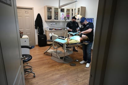 Un odontólogo y su asistente trabajan en la boca de una paciente estadounidense, en la clínica de Rubio Dental Group en Algodones. 