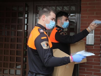 Dos voluntarios de Protección Civil, durante el reparto de mascarillas este jueves en Torrejón de Ardoz, Madrid.