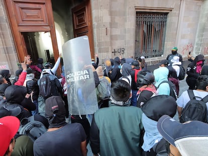 Jóvenes que protestan por la desaparición de los 43 estudiantes de Ayotzinapa rompieron este miércoles una de las puertas principales del Palacio Nacional.