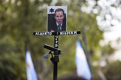 Un manifestante sostiene el retrato del fiscal Nisman junto con una pistola de juguete durante la marcha del silencio en Buenos Aires. Gerardo Pollicita, el fiscal a cargo de la denuncia que efectuó Nisman contra la presidenta de Argentina, ha decidido imputar a Cristina Fernández de Kirchner.