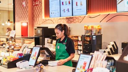 Una empleada consulta los pedidos en el Starbucks del centro comercial Loranca en Fuenlabrada