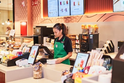 Una empleada consulta los pedidos en el Starbucks del centro comercial Loranca en Fuenlabrada