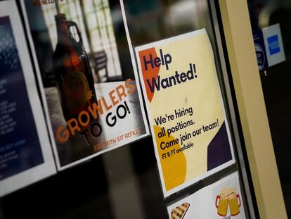 An employee hiring sign is seen in a window of a business in Arlington, Virginia, on April 7, 2023.