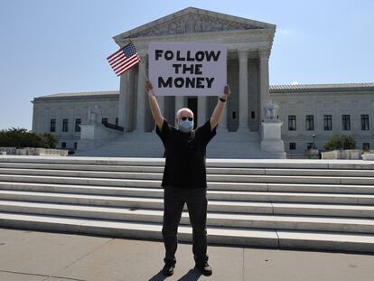 Un manifestante frente al Tribunal Supremo con un cartel en referencia al caso de las finanzas de Donald Trump, este miércoles.