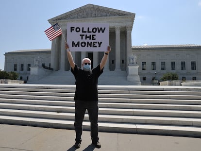 Manifestante diante da Suprema Corte com um cartaz em referência ao caso das finanças de Donald Trump,  na quarta-feira.