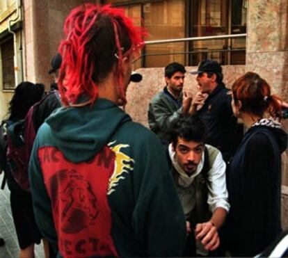 Un grupo de amigos de los <i>okupas</i> detenidos, ayer, discute con un agente a la puerta de los juzgados.