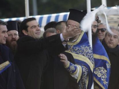 Alexis Tsipras libera una paloma junto al arzobispo Ieronymos durante una ceremonia de la Epifan&iacute;a ortodoxa, este martes en Atenas.