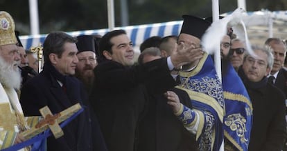 Alexis Tsipras libera una paloma junto al arzobispo Ieronymos durante una ceremonia de la Epifan&iacute;a ortodoxa, este martes en Atenas.