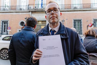 El portavoz del comité de huelga, Juan José Yáñez, sujeta un cuaderno sobre la adecuación salarial de los LAJ, en las puertas del Ministerio, este viernes en Madrid.