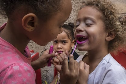 Meninas brincam com batons e maquiagem. Favela da Mangueira, Rio de Janeiro.