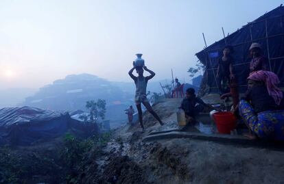 Musulmanes rohingyas transportan agua en el campo de refugiados en Cox's Bazar (Bangladés).