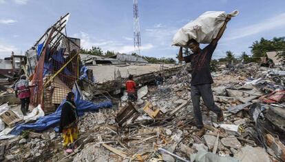 Varias personas buscan sus pertenencias entre los escombros tras el terremoto de 6,5 grados que sacudió la provincia de Aceh, en el norte de Sumatra, Indonesia.