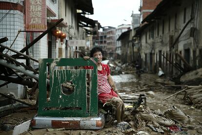 Uma mulher descansa entre as ruínas de uma rua na cidade chinesa de Minqing após a passagem do tufão Nepartak, em 10 de julho de 2016.