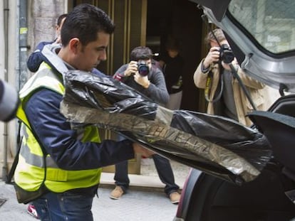 Un agente de la Policía Judicial guarda en un coche una de las cajas con documentación de la Diputación de Huelva.