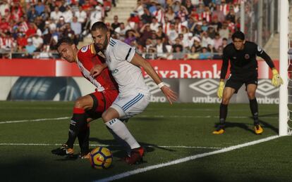 Marc Muniesa (d) y Benzema luchan por el balón.