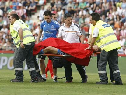 Llorente retirado en camilla junto a, De la Morena, médico del Castilla
 