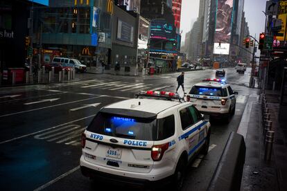 Dos coches de la Policía de Nueva York patrullan por Times Square.