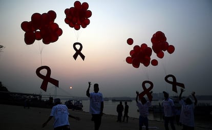 Activistas indios lanzan globos al aire con lazos rojos en Calcuta.