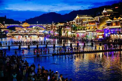 This photo taken on August 5, 2017 shows a night view of the peak tourist season in the ancient town of Fenghuang in Xiangxi, in China's central Hunan province.
The old town district of Fenghuang nestles on the banks of a winding river in a picturesque, mountainous part of Hunan province, and boasts stunning Qing and Ming dynasty architecture dating back hundreds of years. / AFP PHOTO / STR / China OUT