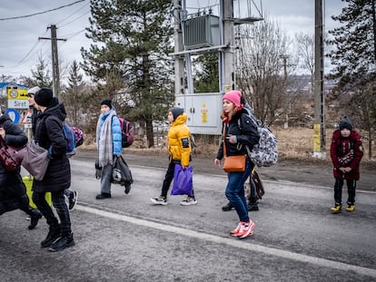 Refugiados ucranios, cerca del paso fronterizo de Siret, en Rumania, este domingo.