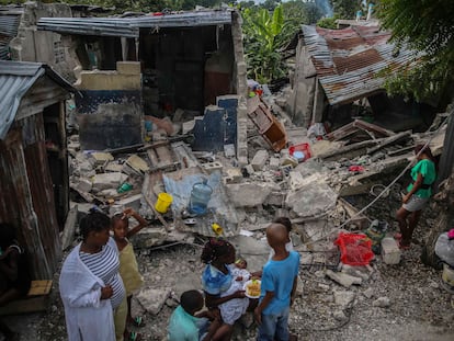 Una familia desayuna junto a su casa destruida por el terremoto del sábado en Les Cayes, Haití.