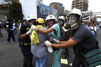 Un grupo de voluntarios médicos ayudan a una persona afectada por los gases lacrimógenos.