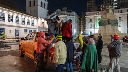 Moradores de rua se aproximam de um carro de voluntários que distribuiram alimentos, cobertores e agasalhos no Pátio do Colégio, centro de São Paulo.