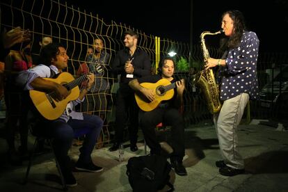 Jorge Pardo con el saxo y los miembros de la Huellas Band Diego Guerrero en el centro y Josemi Carmona a la izquierda calientan motores antes de salir al escenario. En segundo plano Yuno de "los mellis" da palmas.