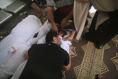 Un hombre llora ante los cuerpos de varios familiares muertos en el bombardeo israelí de la franja de Gaza, este lunes.