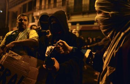 Unos enmascarados se disponen a prender fuego a un cóctel molotov durante el enfrentamiento con la policía en Río de Janeiro (Brasil), 7 de octubre de 2013.