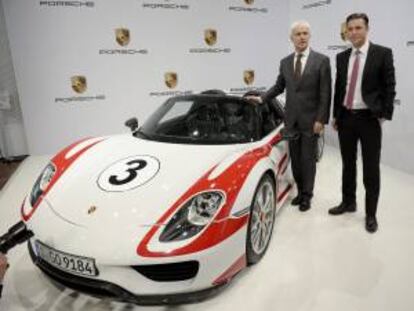 El presidente y consejero delegado de Porsche, Matthias Mller (izda), y su director financiero, Lutz Meschke (dcha), posan junto a un Porsche 918 Spyder durante una rueda de prensa para anunciar los resultados de la compa?a en el Museo de Porsche en Stuttgart (Alemania) hoy. EFE Weissbrod