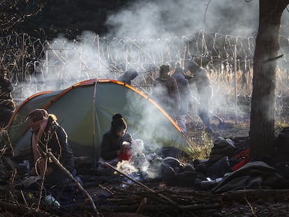 Mulher dá mamadeira a seu bebê no acampamento de imigrantes na fronteira de Belarus com a Polônia, nesta quarta-feira.