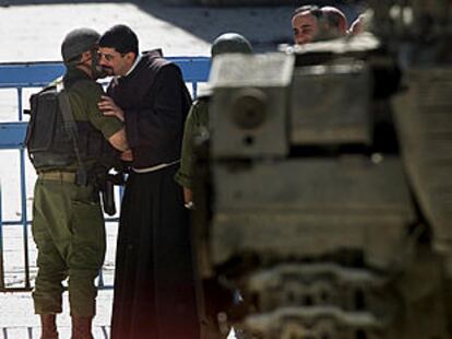 Un fraile de la iglesia de la Natividad besa a un soldado israelí al salir  del templo.