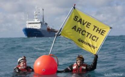 Dos activistas de Greenpeace ante el buque ruso de prospección Académico Lazarev, en el mar de Barents, con la pancarta "Salvar el Ártico".