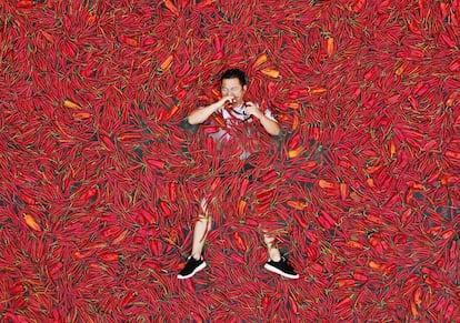 El gusto por el picante es un modo de masoquismo benigno. En la foto, un hombre yace en una piscina cubierta de chiles durante un concurso en China.