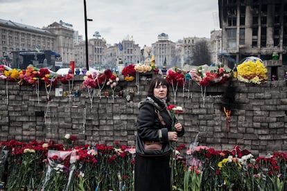 Una mujer lleva flores en un monumento improvisado a las víctimas de la revuelta de Maidán (Kiev) el 23 de febrero de 2014.