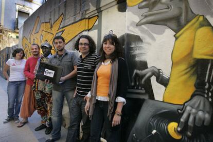 Jóvenes de varias asociaciones posan junto a una pintada en Alicante.