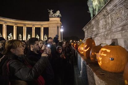 Un grupo de personas fotografía calabazas vaciadas e iluminadas con motivo de Halloween, en Budapest (Hungría), el 27 de octubre de 2018.