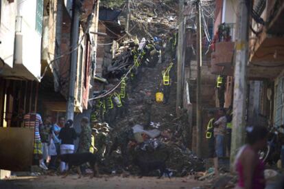 Una cadena de soldados retiran escombros de las ruinas de La Gabriela, barriada de Medillín.