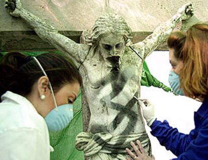 Dos restauradoras reparan la imagen del Cristo de los Tres Faroles de Córdoba.