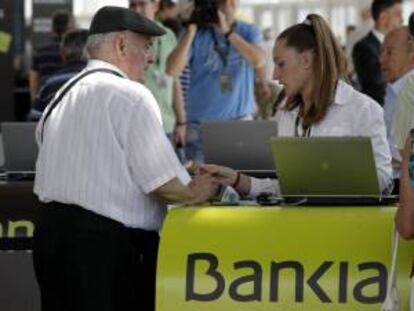 Una persona se acredita para poder acceder a la sala del Palacio de Congresos de valencia donde ayer se celebró la Junta General de accionistas de Bankia .