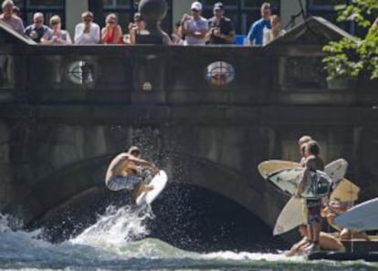 Surfistas en la llamada 'ola de Eisbach', junto a la calle Prinzregenten, en Múnich (Alemania).