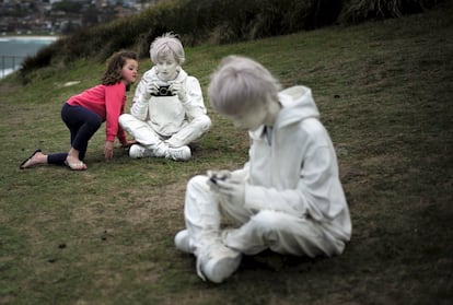 Una niña curiosea la escultura de fibra de vidrio y hierro titulada 'Cotidaneidad, del artista italiano Fabio Pietrantonio, durante la 19 edición de 'Sculpture by the Sea'.