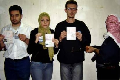 Los tres periodistas secuestrados muestran sus pasaportes ante uno de sus captores.