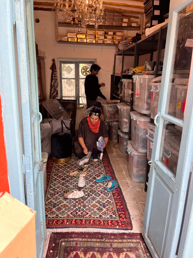 La diseñadora iraní Mehrnoosh Shahhosseini ordena los zapatos que almacena en su casa ya que no ha podido venderlos debido a la falta de conexión a internet.