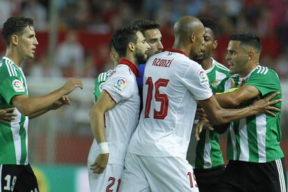 Los jugadores del Real Betis y del Sevilla, se enfrentan tras una jugada durante el partido.