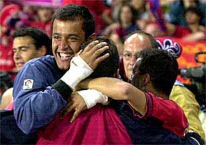 Varios jugadores de Osasuna se funden en un abrazo celebrando la permanencia.